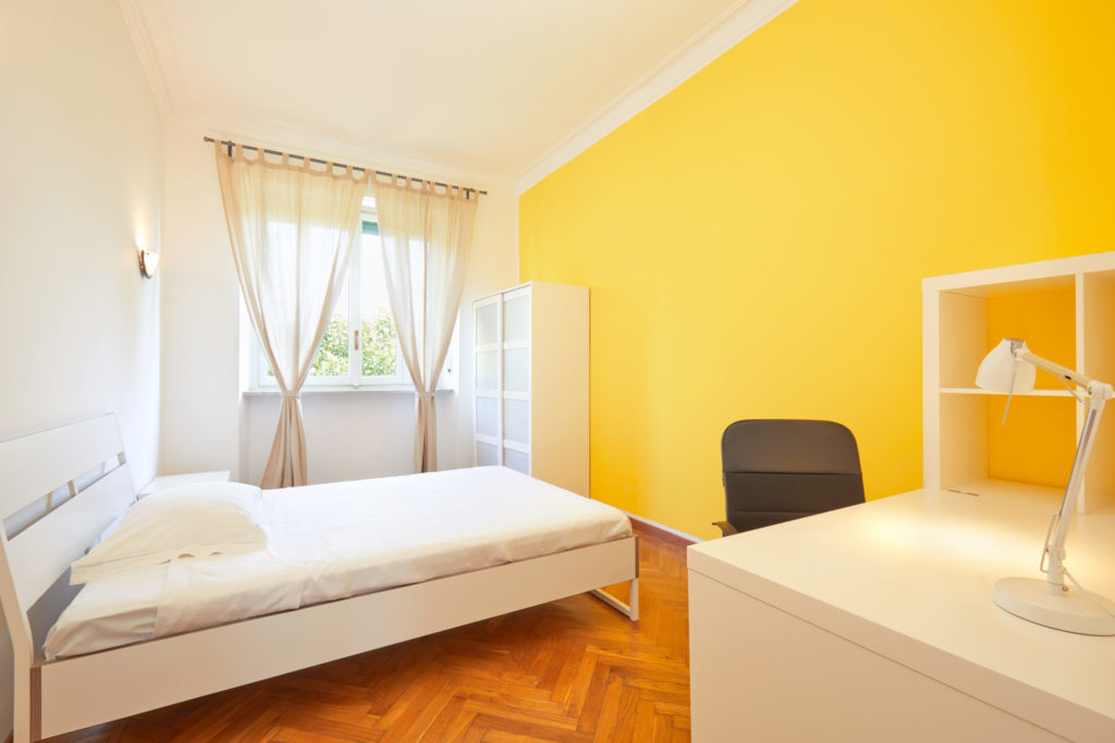 Bedroom for rent in renovated apartment with yellow wall and whi