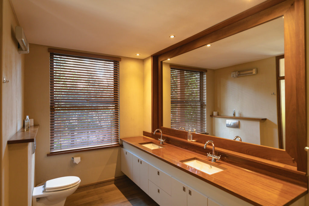 Interior of sunny, modern bathroom with beautiful big mirror. modern architecture and domestic interior design.