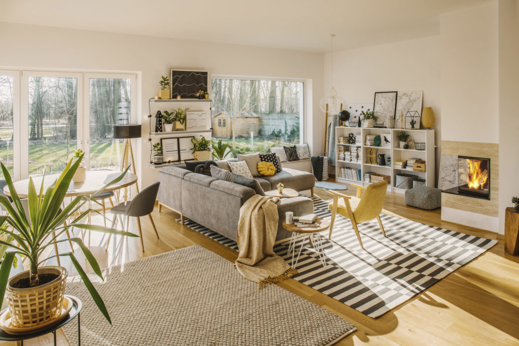 Two carpets on the floor in white Scandi living room interior wi
